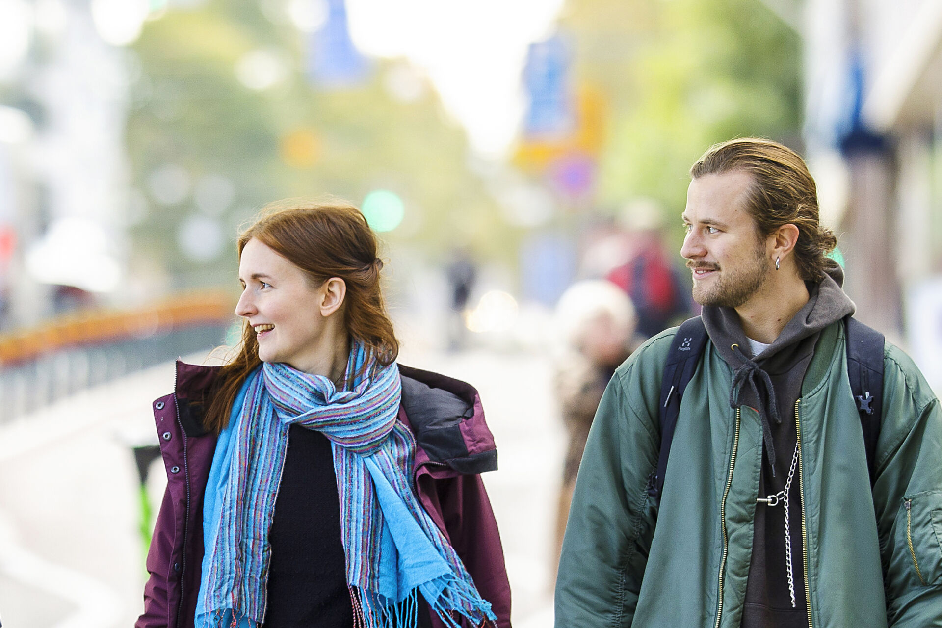 Noin 30-vuotiaat nainen ja mies katsovat oikealle.