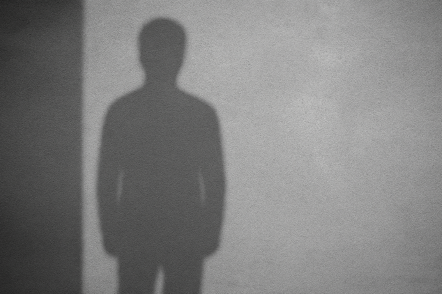 Hahmon varjokuva betoniseinän edessä